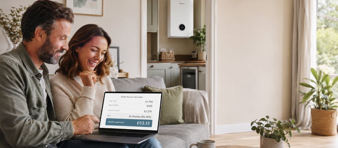 Happy British couple using a laptop to calculate affordable monthly finance payments for a new Worcester Bosch boiler in a modern UK living room.